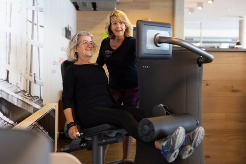 Gesundheitstraining Betreuung mit Mitglied und Trainerin bei einer Übung auf einem egym Zirkeltraining-Gerät im Fit 'n Fun Gau-Algesheim bei Ingelheim