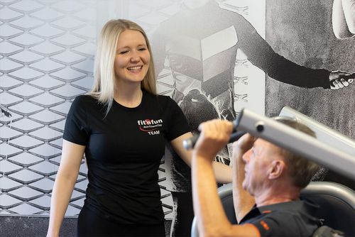 Fitnesstraining Betreuung mit Mitglied und Trainerin bei einer Übung an einem Kraftgerät im Fit 'n Fun Gau-Algesheim bei Ingelheim