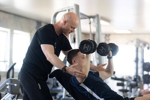 Fitnesstraining Betreuung mit Mitglied und Trainer bei einer Übung mit Handeln im Fit 'n Fun Gau-Algesheim bei Ingelheim