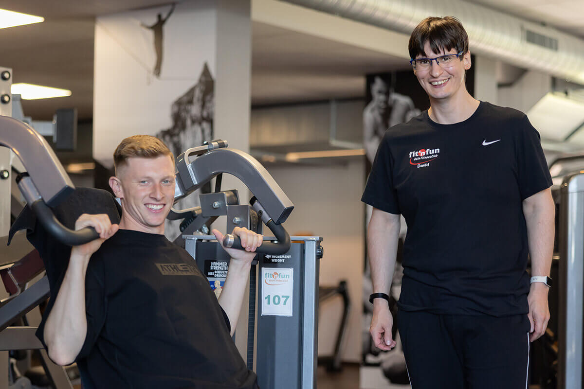 Fitnessgerät Betreuung mit Mitglied und Trainer bei einer Übung am Fitnessgerät im Fit 'n Fun Gau-Algesheim bei Ingelheim